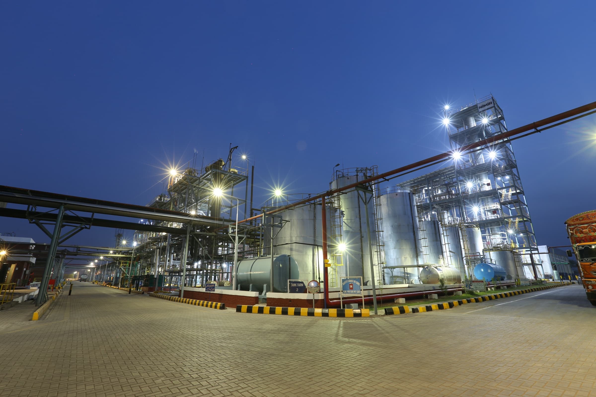 Manufacturing plant lit at twilight — round-the-clock operations